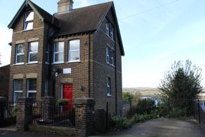 a brown brick house with a red door at Botleigh Villa in Rochester