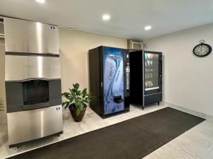 uma sala com uma máquina de venda automática de bebidas e um relógio em Royal Inn and Suites Charlotte Airport em Charlotte