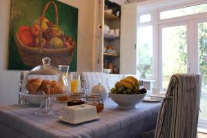 Botleigh Villa في روتشستر: طاولة مع وعاء من الفواكه وسلة من الخبز