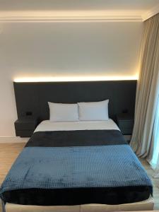 uma cama com cabeceira preta e almofadas brancas em HOTEL PERDIZES - FLAT Executivo - 504 em São Paulo