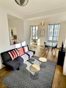 uma sala de estar com um sofá e uma mesa em WonderHost, au cœur du quartier du château em Pau