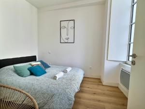um quarto com uma cama com almofadas azuis em WonderHost, au cœur du quartier du château em Pau