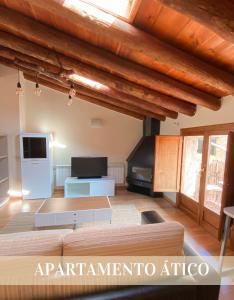 ein Wohnzimmer mit einem Sofa und einem TV in der Unterkunft Alojamientos Apolonia, La Fresneda in La Fresneda