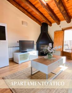 ein Wohnzimmer mit einem TV und einem Couchtisch in der Unterkunft Alojamientos Apolonia, La Fresneda in La Fresneda