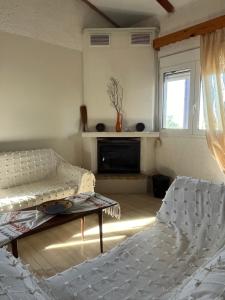 a living room with two beds and a fireplace at Kamera House in Khordhákion