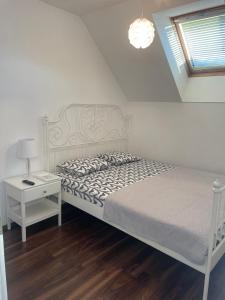 Habitación blanca con cama y mesita de noche en Tara's apartment, en Vrhnika