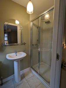 a bathroom with a glass shower and a sink at TeachinTom in Strabane