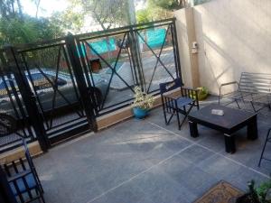 Un patio con sillas y una mesa en el balcón. en Hostel Bauti en Ezeiza en Ezeiza