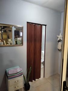 baño con espejo y armario de madera en Hostel Bauti en Ezeiza en Ezeiza