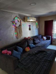 a living room with a blue couch and decorations at Hostel Bauti en Ezeiza in Ezeiza