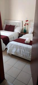 duas camas num quarto de hotel com em MAMU'S RESIDENCE near JKIA em Nairobi
