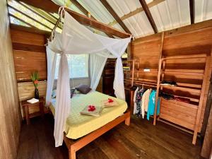 a bedroom with a bed with a mosquito net at Casa Maniki in Nuquí