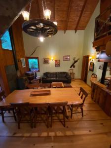 a living room with a wooden table and a couch at casa del Leñador Huilo Huilo in Puerto Fuy