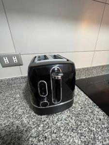 a black toaster sitting on top of a counter at Apartamento General Mackenna B&E in Santiago