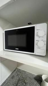 a microwave oven sitting on a white counter at Apartamento General Mackenna B&E in Santiago