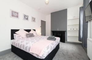 a bedroom with a large bed and a fireplace at Modern home near the hopsital in Exeter