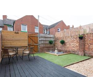 a backyard with a table and chairs on a wooden deck at Modern home near the hopsital in Exeter