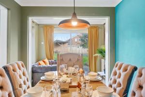 - une salle à manger avec une table et des chaises dans l'établissement BridgeCity Luxurious Maidstone Holiday Home, à Kent
