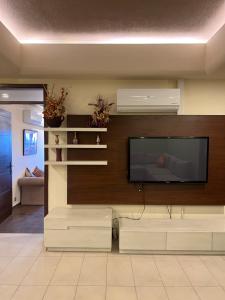 een woonkamer met een flatscreen-tv aan de muur bij Sky Suite in Islamabad