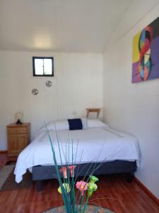 a bedroom with a bed and a potted plant at Alojamiento Ximena in Coñaripe