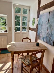 a dining room with a wooden table and chairs at Mecklenbü mit Teich, Kamin, Sauna und Hotpott in Dargun