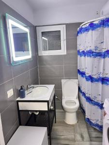 a bathroom with a toilet and a sink and a window at Village House in Himare