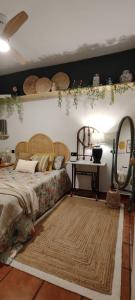 a bedroom with a bed and a table and a mirror at El 6 De Busquet in Cáceres