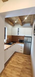 cocina con armarios blancos y nevera de acero inoxidable en Prima View en Karpacz
