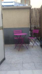due tavoli e sedie rosa accanto a un muro di Appartement cosy de 50m2, 2 chambres avec terrasse, plein centre d'Ax-les-Thermes ad Ax-les-Thermes