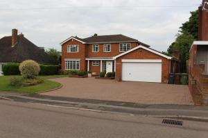 a brown brick house with a white garage at Lovely 10-Bed House in Birmingham with a big drive in Birmingham