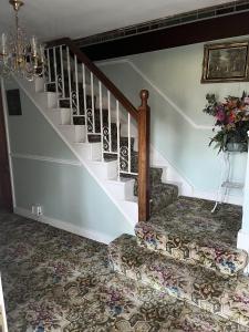 a stairway with a couch and a stair case at Lovely 10-Bed House in Birmingham with a big drive in Birmingham