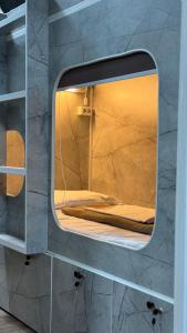 - un miroir sur une étagère avec un lit dans l'établissement SAM Hostel, à Gornyy Gigant