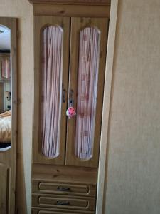 Vestidor de madera con 3 ventanas en un dormitorio en Martins paradise en Mablethorpe