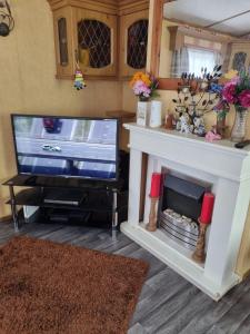 sala de estar con TV y chimenea en Martins paradise en Mablethorpe