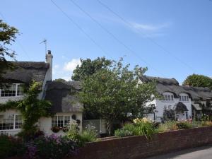 an old cottage with flowers in front of it at 2 Bed in Winterton on Sea 29236 in Winterton-on-Sea