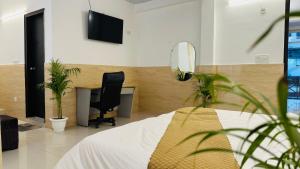 a bedroom with a desk and a bed and a chair at Hotel Relax In - Noida Sector 18 in Noida