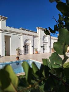 ein großes weißes Gebäude mit einem Pool davor in der Unterkunft B&B Le Torri in Santeramo in Colle