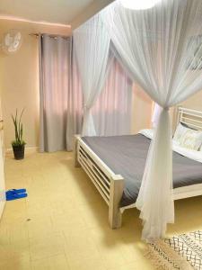 um quarto com uma cama de dossel e cortinas em Pristine Luxury 2 bedroom Apartment-South C em Nairobi