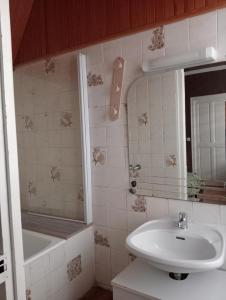a bathroom with a sink and a mirror and a tub at F2 1ER ETAGE - 5 min du Lac de Madine in Vigneulles-lès-Hattonchâtel +8 photos