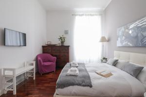 a white bedroom with a large white bed and a window at Luxury and elegant apartment Rome Vatican in Rome