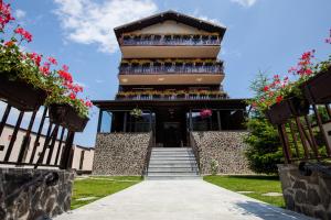 um edifício com uma escada que o leva até ele em Pensiunea Noni em Azuga