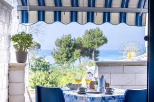 a table with wine glasses and a view of the ocean at Le Perle Marine in Torre Vado