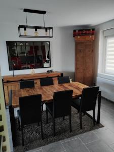 a dining room with a wooden table and chairs at La maison des noyers in Parigné-lʼÉvêque