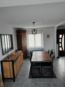 a dining room with a wooden table and chairs at La maison des noyers in Parigné-lʼÉvêque