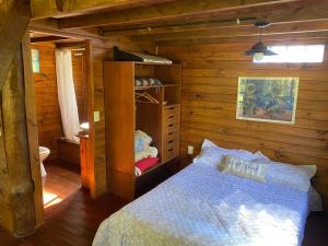 um quarto com uma cama num chalé de madeira em Cabañas El Tercer Ojo Tigre em Tigre