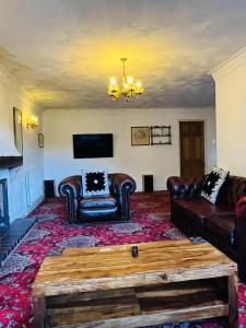 a living room with leather furniture and a chandelier at Unwind in comfort at cosy Caradus Free parking in Birmingham