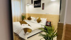 a bedroom with a bed with white sheets and pillows at Hotel Relax In - Noida Sector 18 in Noida