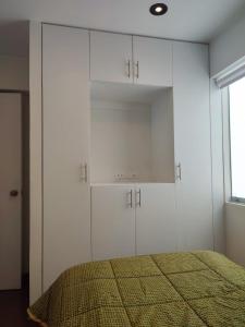利馬的住宿－Apartamento entero en el más importante centro financiero, bursátil, San Isidro, Lima, Peru，卧室配有白色橱柜和1张床。