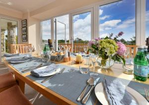 a dining room table with a vase of flowers on it at The Summer House in Abersoch