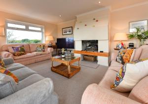 a living room with two couches and a fireplace at The Summer House in Abersoch